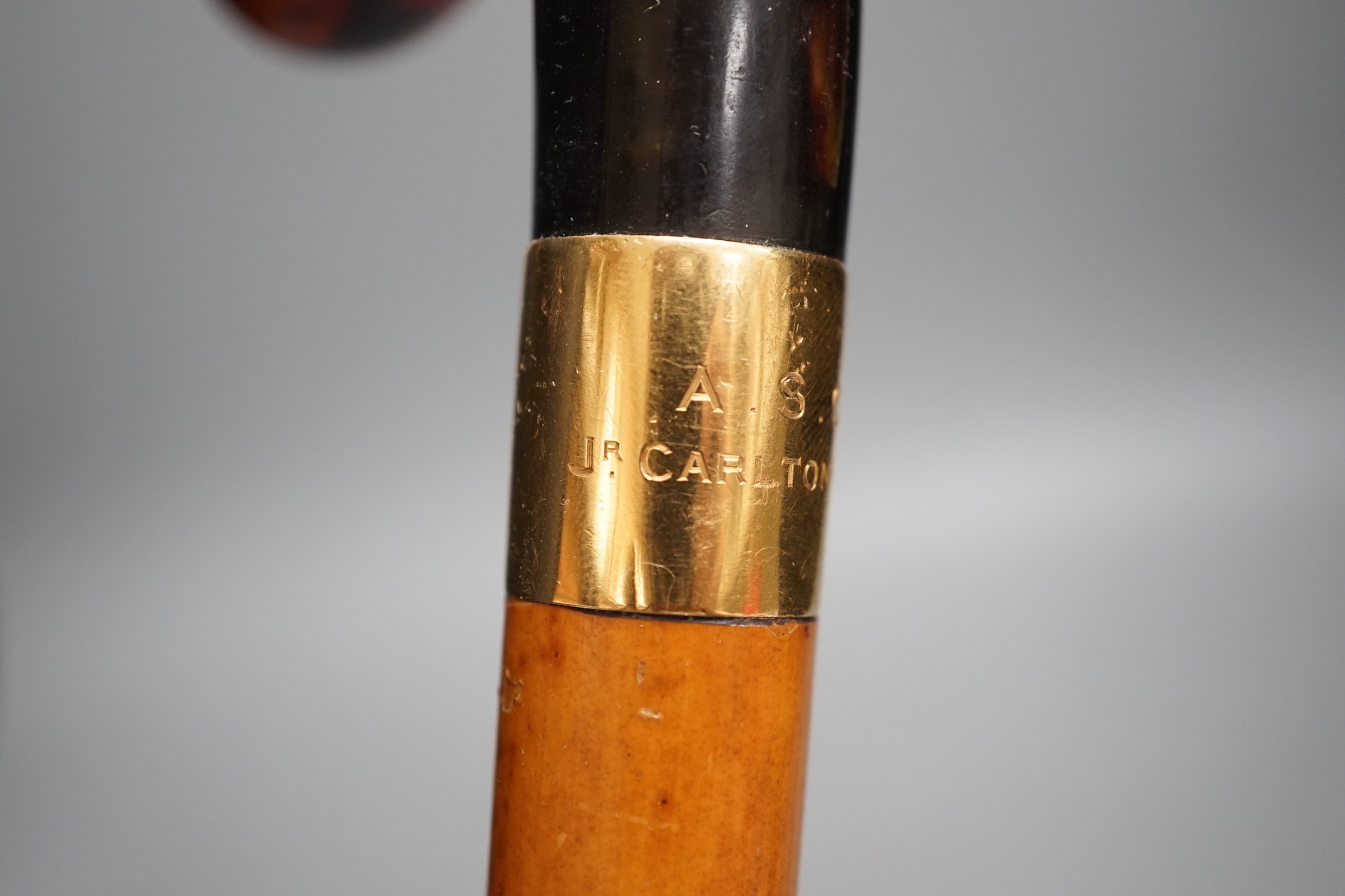 An 18ct gold collared malacca cane, with a horn handled handle, stained as tortoiseshell, 94 cms long